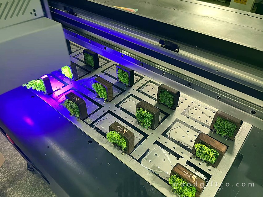 UV printer running over walnut boxes with preserved moss